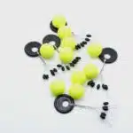 Ein Haufen Pilotkugeln in Gelb mit Schnurstoppern aus Gummi in schwarz