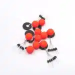 Ein Haufen Pilotkugeln in Rot mit Schnurstoppern aus Gummi in schwarz