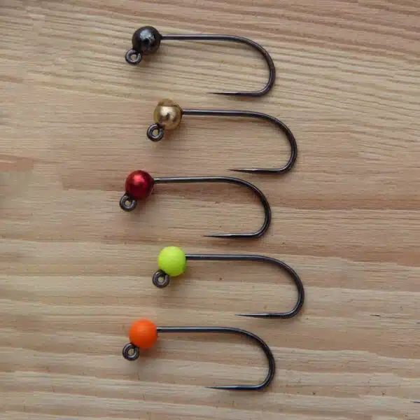 Fuenf montierte Tungstenhaken mit farbigen Tungstenperlen auf Holzbrett