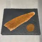 Lachsforellenfilet mit Orangenpfeffer Topping auf Schieferplatte