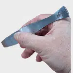 Graetenpinzette aus Edelstahl in der Hand auf neutralem Hintergrund