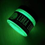Eine Dose Libra Lures Forellenköder in Glow mit UV Licht angeleuchtet